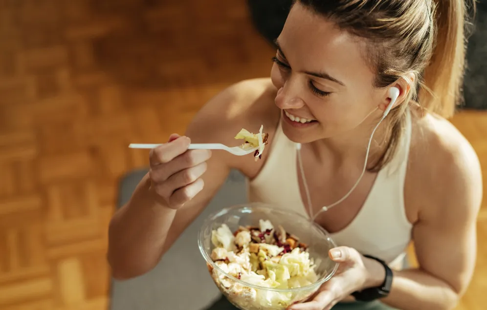 Mujer comiendo almuerzo balanceado luego de hacer ejercicio