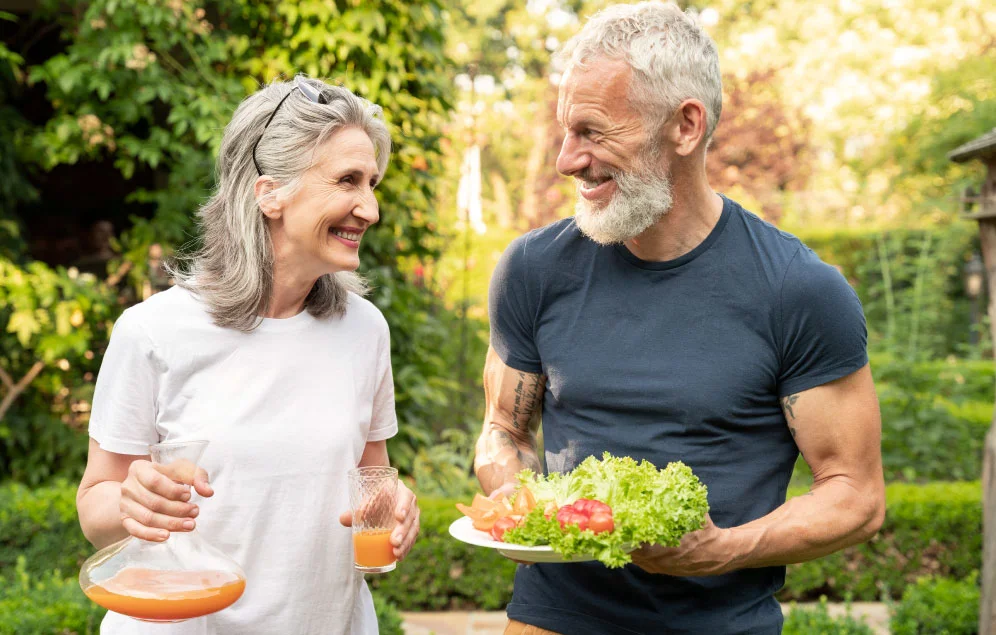 Pareja de adultos mayore, realizando ejercicio y alimentándose de manera saludable, para así poder prevenir enfermedades cardiovasculares.